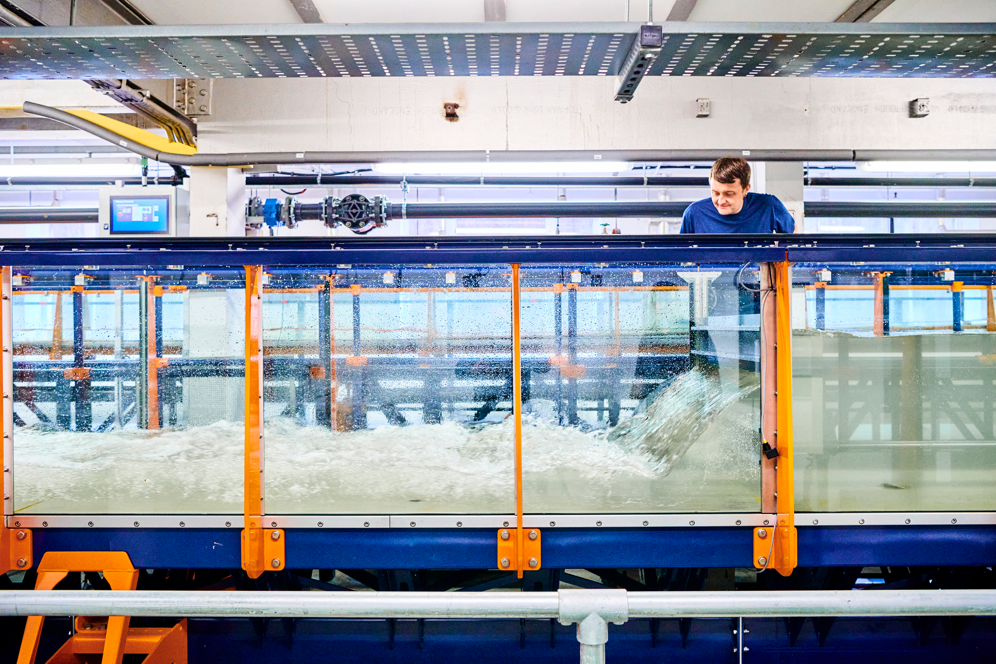 An engineer looks down at water pouring through an experiment