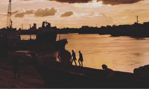 Workers on the quayside at dusk in Chittagong, Bangladesh. (Image: https://unsplash.com/@safwan_mahmud)