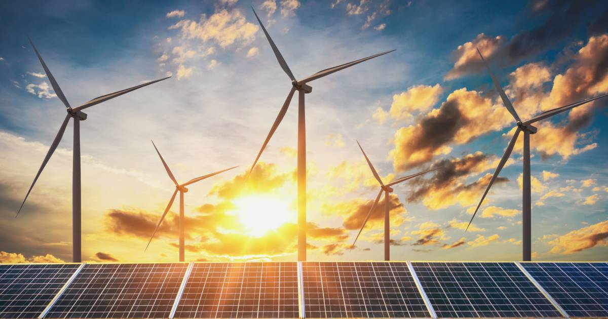 Wind turbines and solar panels with sunset background